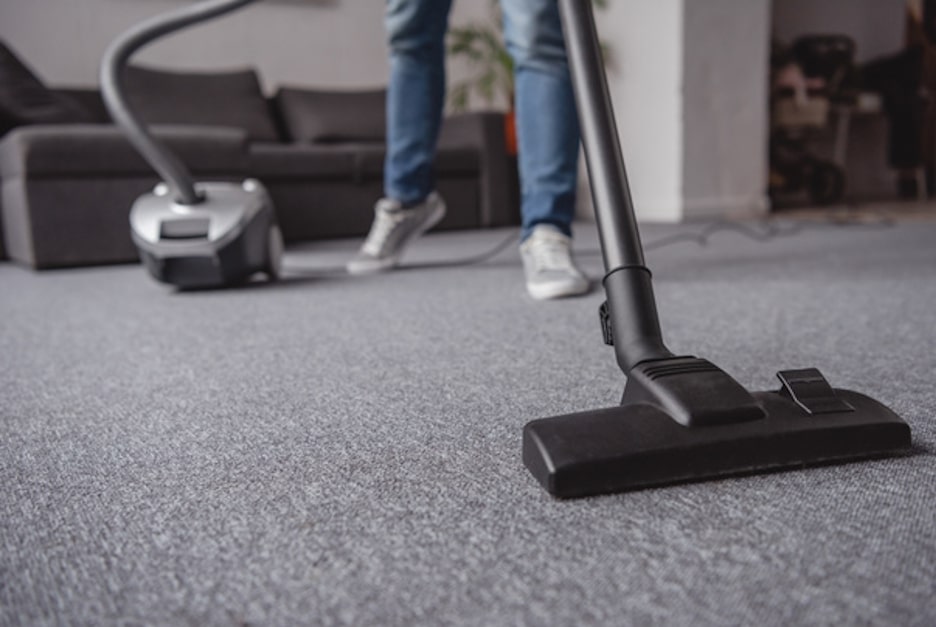 Professional cleaner using commercial-grade vacuum in home